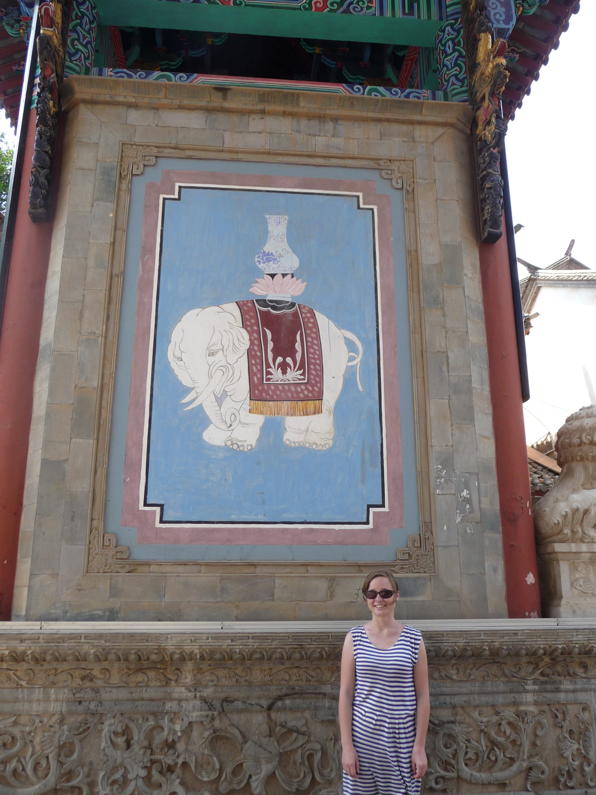 Charlotte in der Guandu Old Town in Kunming. Im Hintergrund eine Wandmalerei eines Elefanten. 